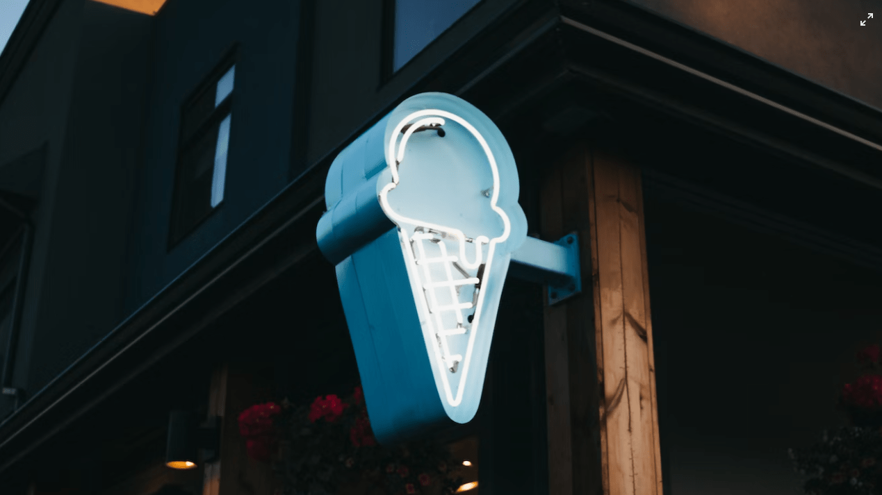 a blue ice cream sign attached to a ice cream shop trying to boost ice cream sales when rain is coming
