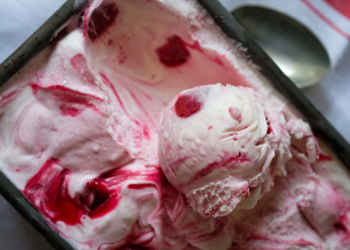 An example of a new ice cream flavour, scoop of colourful pink ice cream in its tub. 