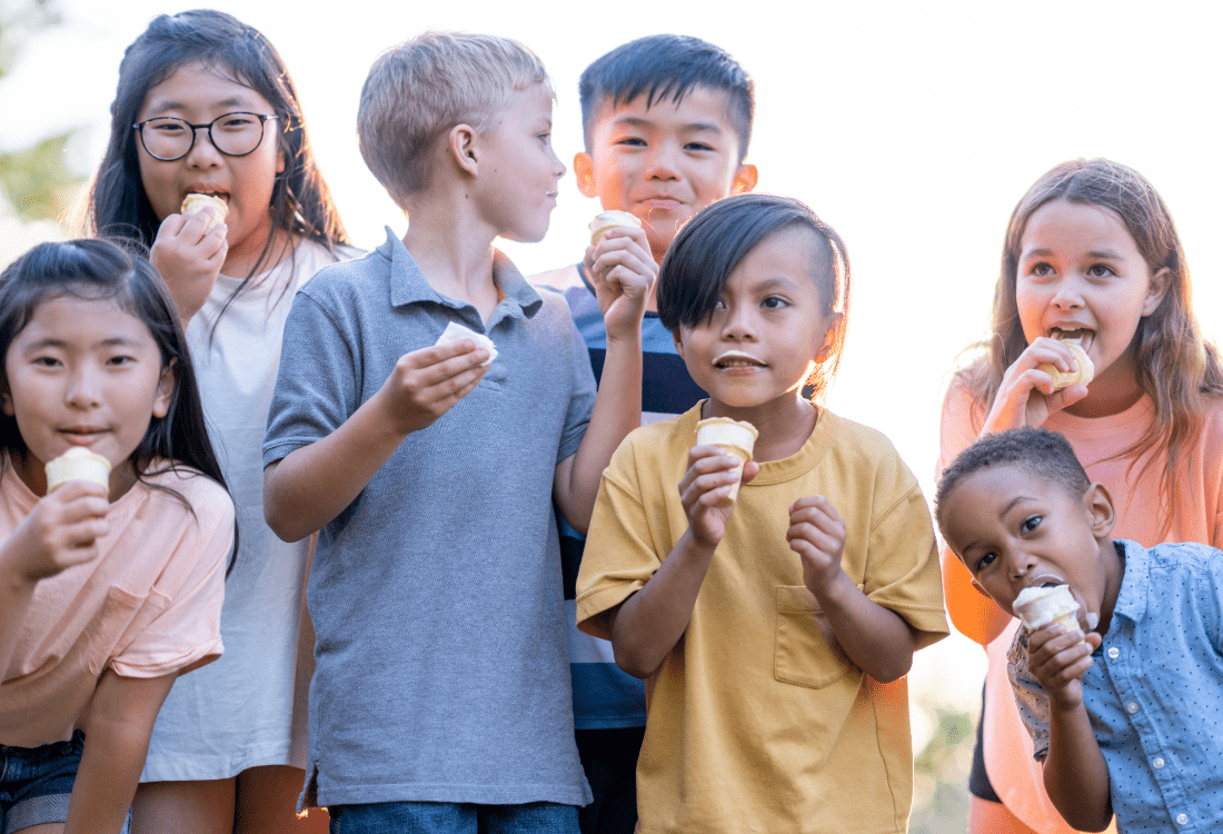 A group of children eating ice cream from parlour that has introduced samples to increase summer sales. 