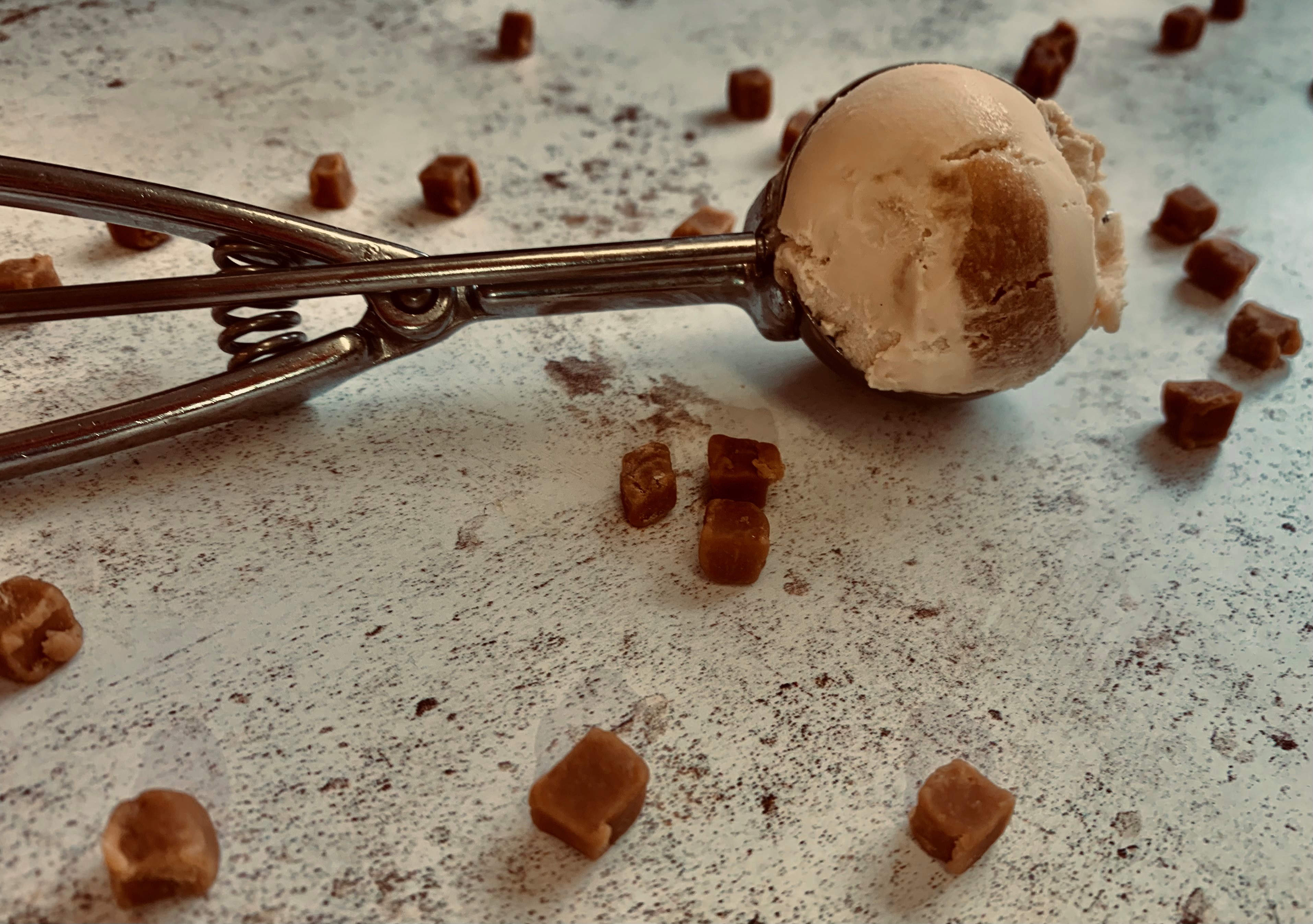 Caramel swirl ice cream with scattered caramel and the full scoop